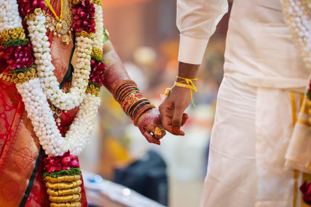 Indian couple holding hand close up in wedding ceremony.